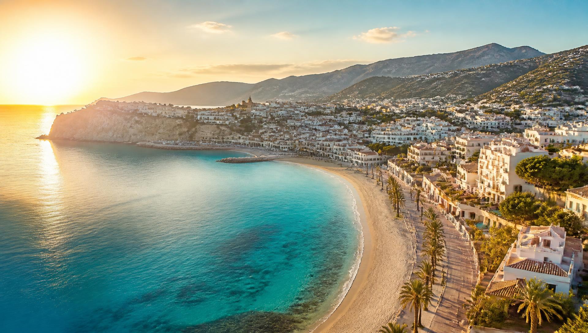 Costa Blanca coastline at golden hour with turquoise sea and palm-lined promenade
